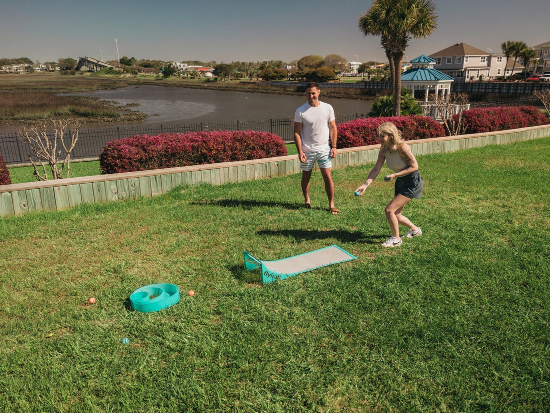 Flyball balls in every color laid out on the beach next to the ramp and target ring